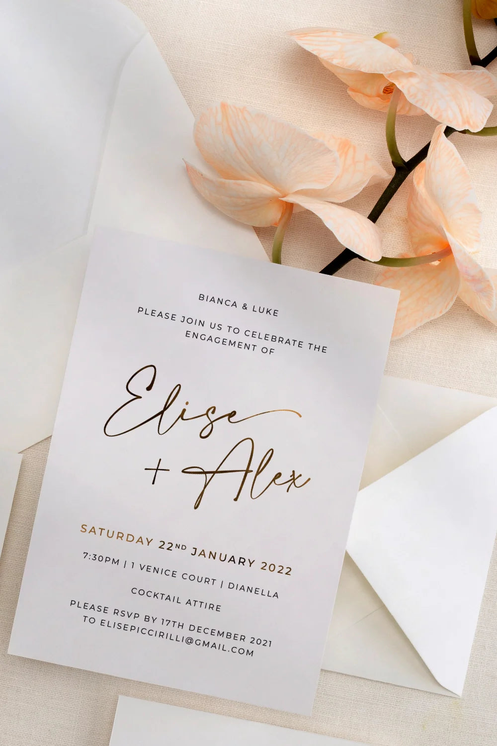 Engagement invitation for Elise and Alex with gold script calligraphy and peach orchids by Felicitations