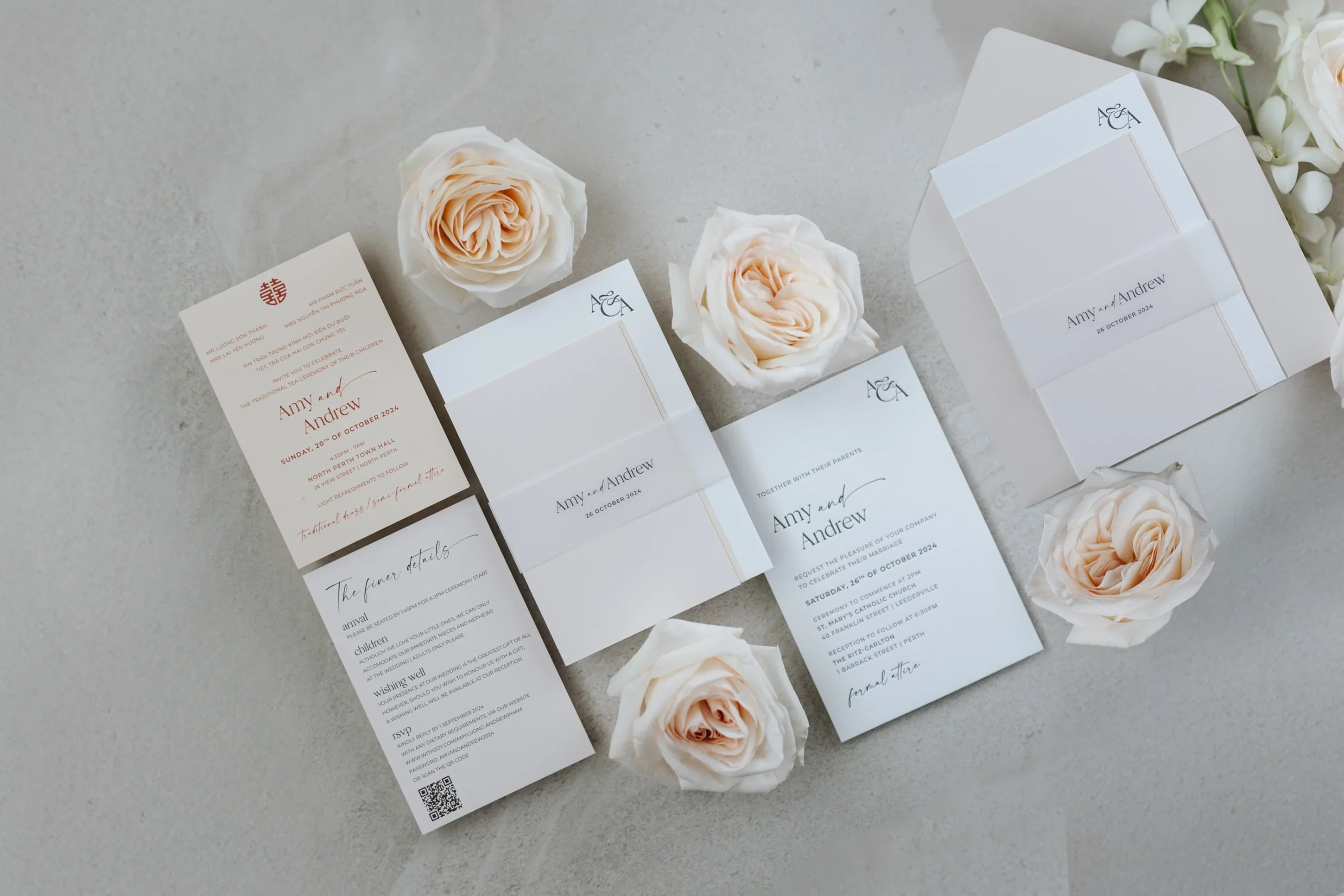 Elegant letterpress wedding invitations for Amy and Andrew with white roses on concrete