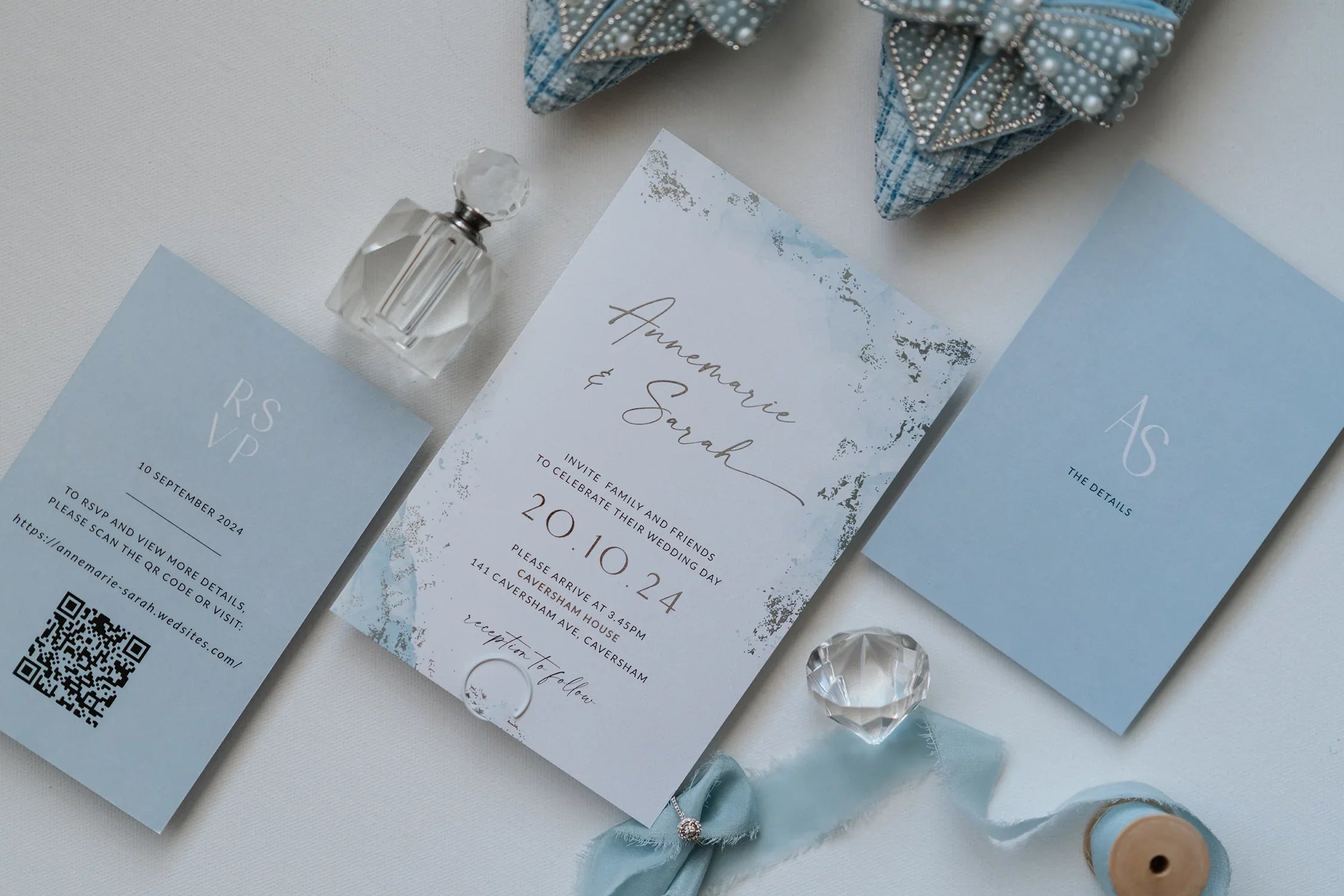 Elegant blue and white wedding invitations and RSVP cards with crystal decor and ribbon detail