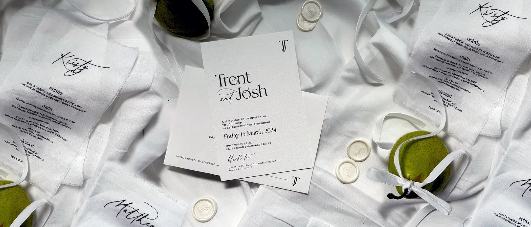 Elegant black and white wedding invitation and linen menus for Trent and Josh with white wax seals and green pears