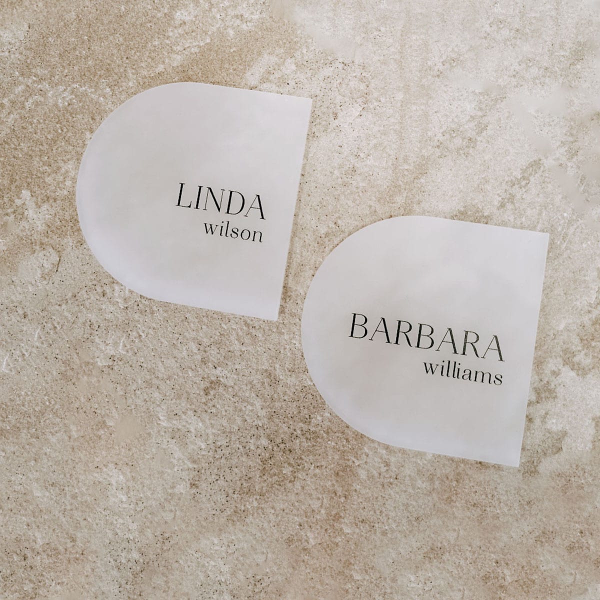 Frosted acrylic arch place cards with guest names Linda Wilson and Barbara Williams by Felicitations