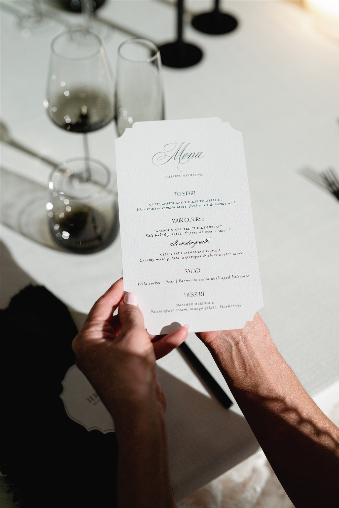 The Verona Suite ornate cartouche shaped wedding menu with elegant calligraphy on reception table by Felicitations
