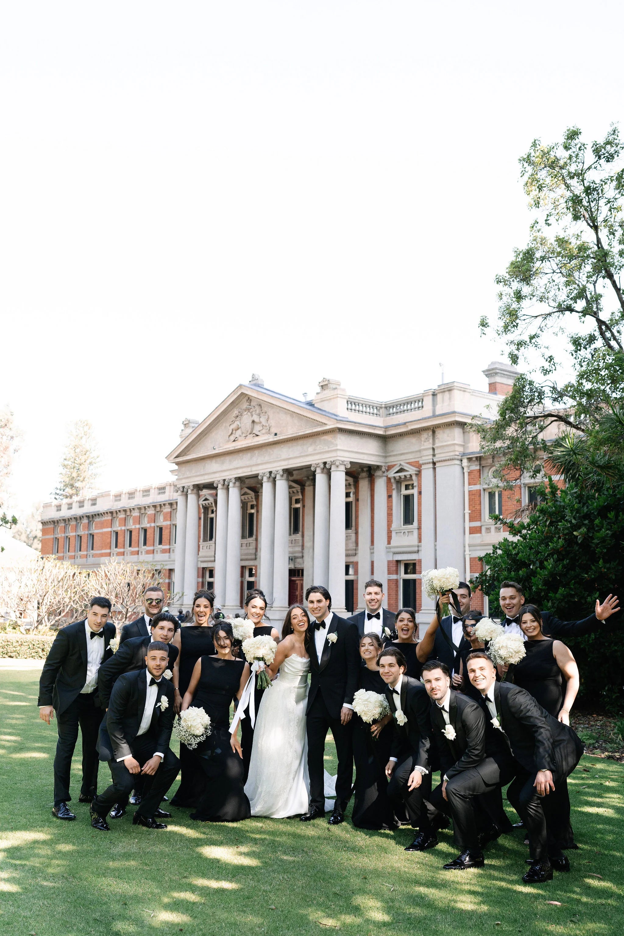 Wedding party posing in front of a historic building