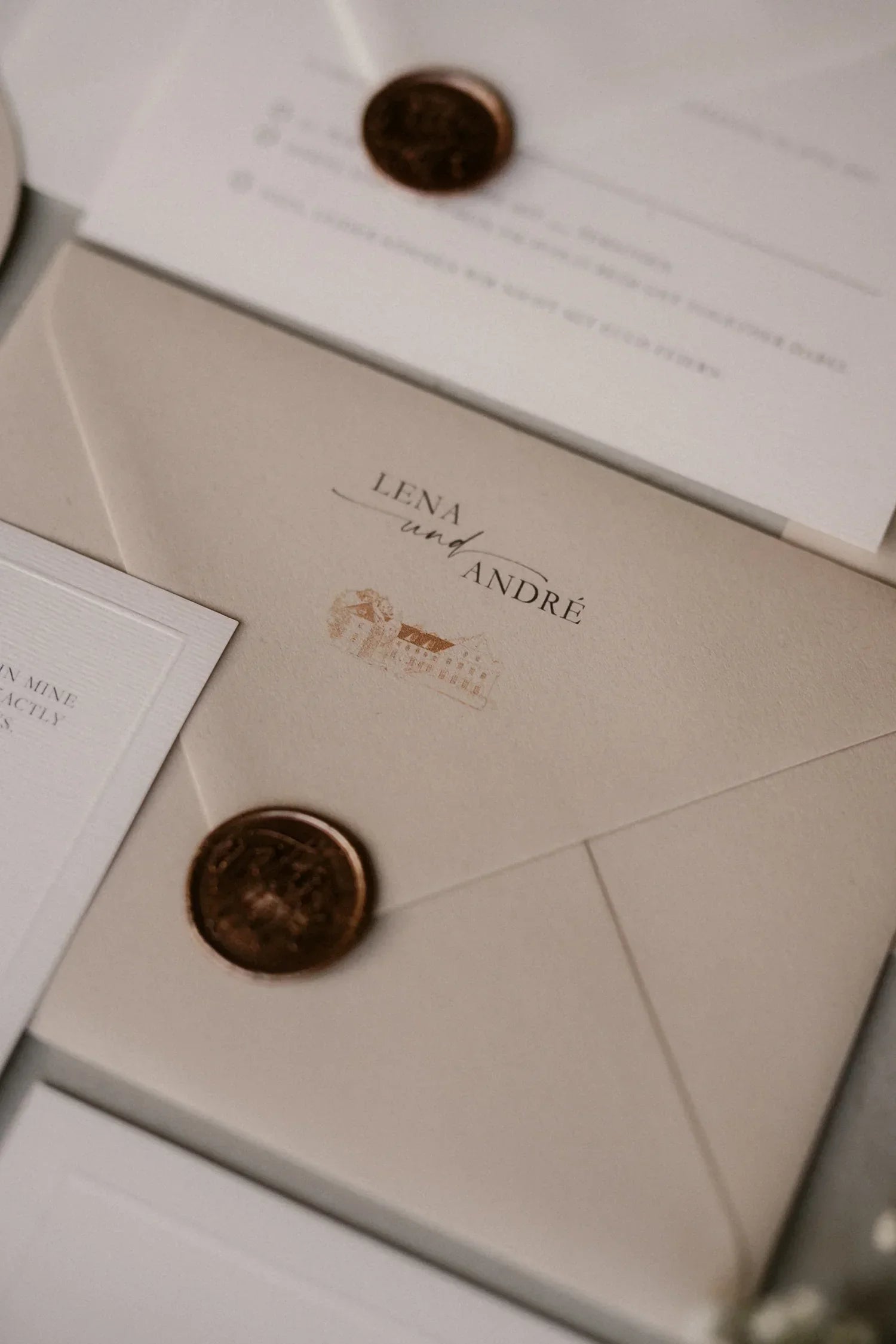 Elegant beige wedding invitation envelope with wax seal and names Lena and André