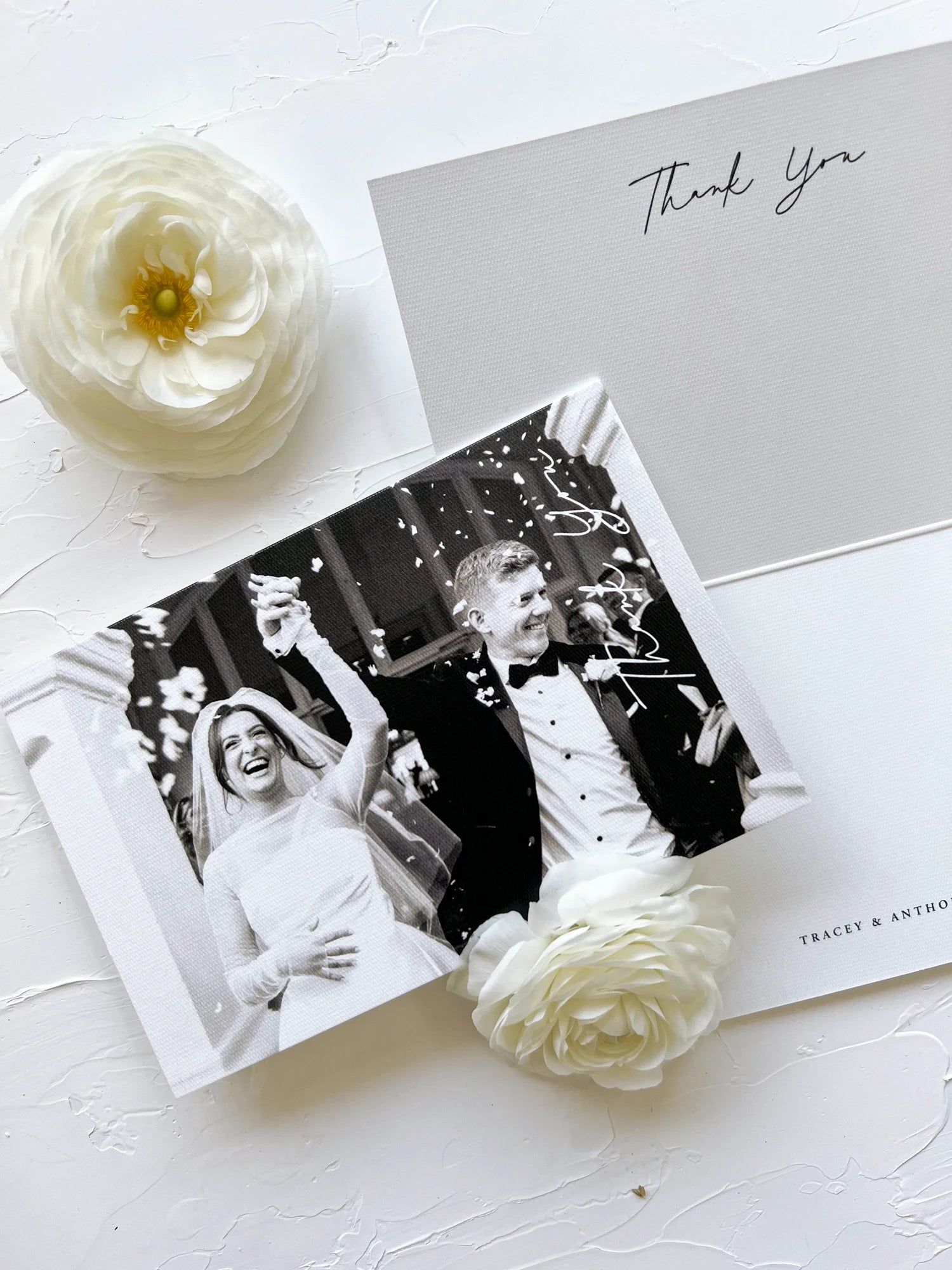 A personalized photo thank you card set for 'Tracey & Anthony', pairing a joyous black and white wedding photo with a minimalist script thank you note.