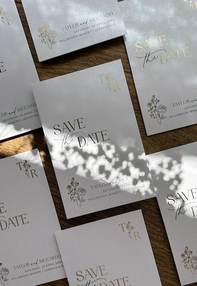 Gold foil Save the Date suite for Taylor and Riccardo Millbrook Winery Jarrahdale, monogram and floral motif on cream cardstock flat-lay