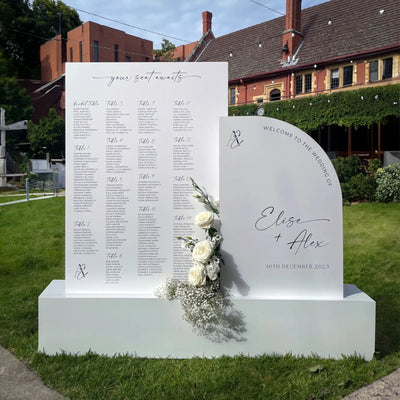 Outdoor wedding seating chart and arch welcome sign for Elise and Alex 16th December 2023, styled with white roses and baby's breath at heritage venue