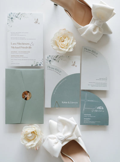 The Garda Suite full wedding invitation set with sage envelope arch invitation eucalyptus florals and bridal heels by Felicitations