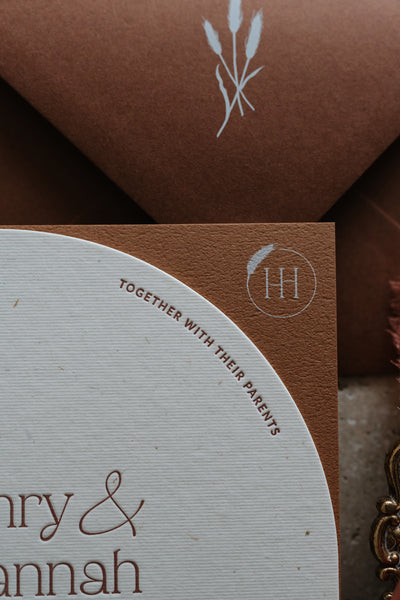 The Seville Suite terracotta envelope with white wheat illustration and arch invitation by Felicitations