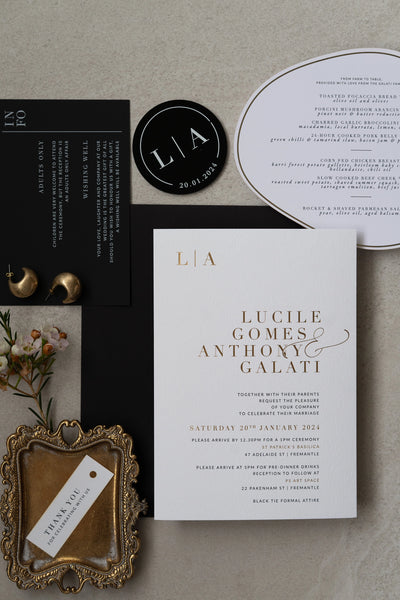 The Zurich Suite full wedding stationery flat lay with gold foil invitation black info card and arch shaped menu by Felicitations